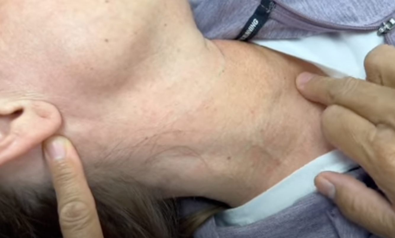 Doctor examines patient's neck for lymph nodes.